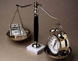 A set of scales balances a gold alarm clock with a stack of dollar bills